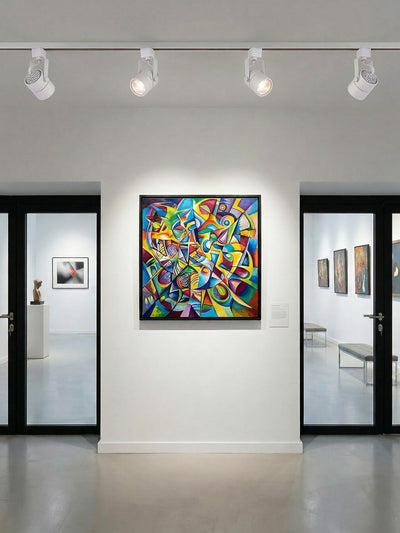 2 matte white track heads spot-lighting framed art on a gallery wall