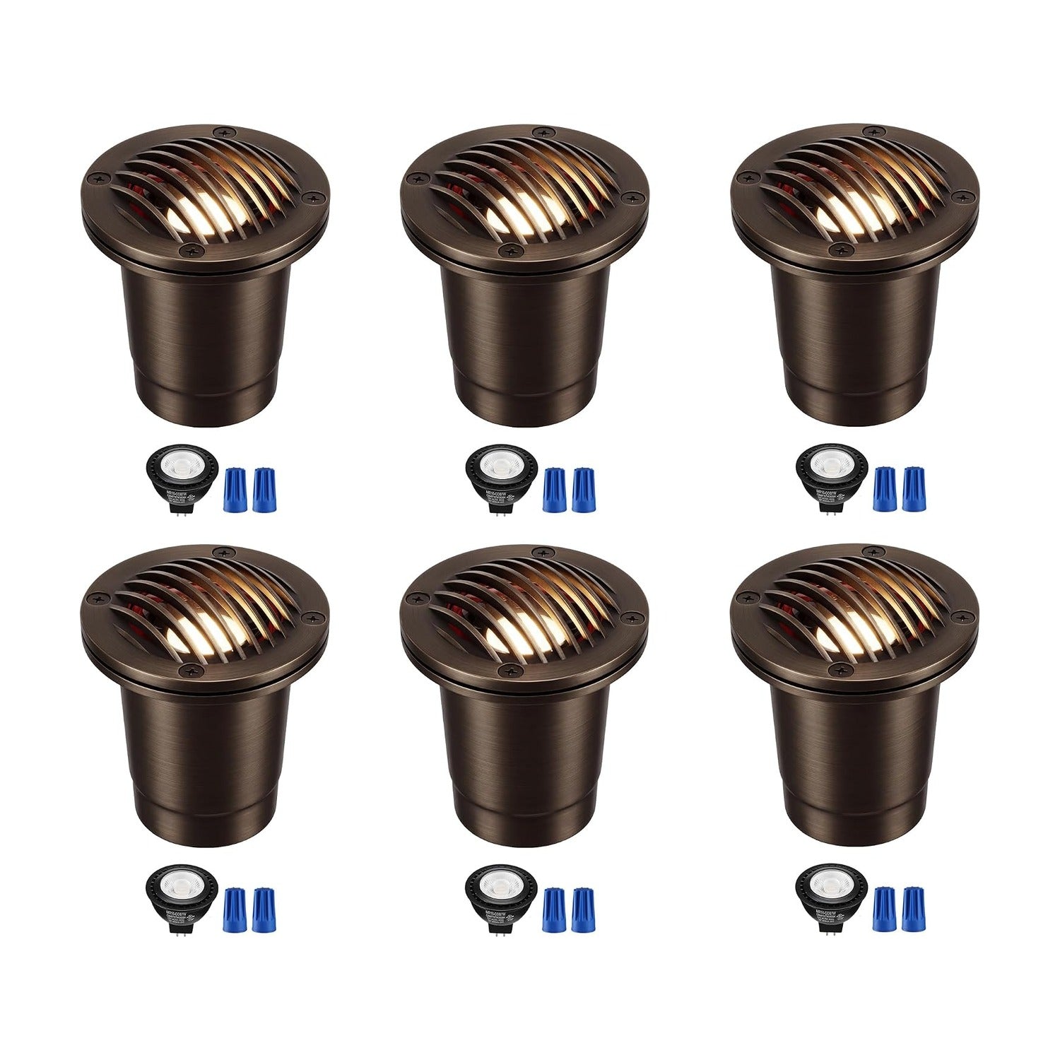 Set of 6 black low voltage in-ground well lights installed in a garden bed, illuminating warm white light upward at plants and foliage at night